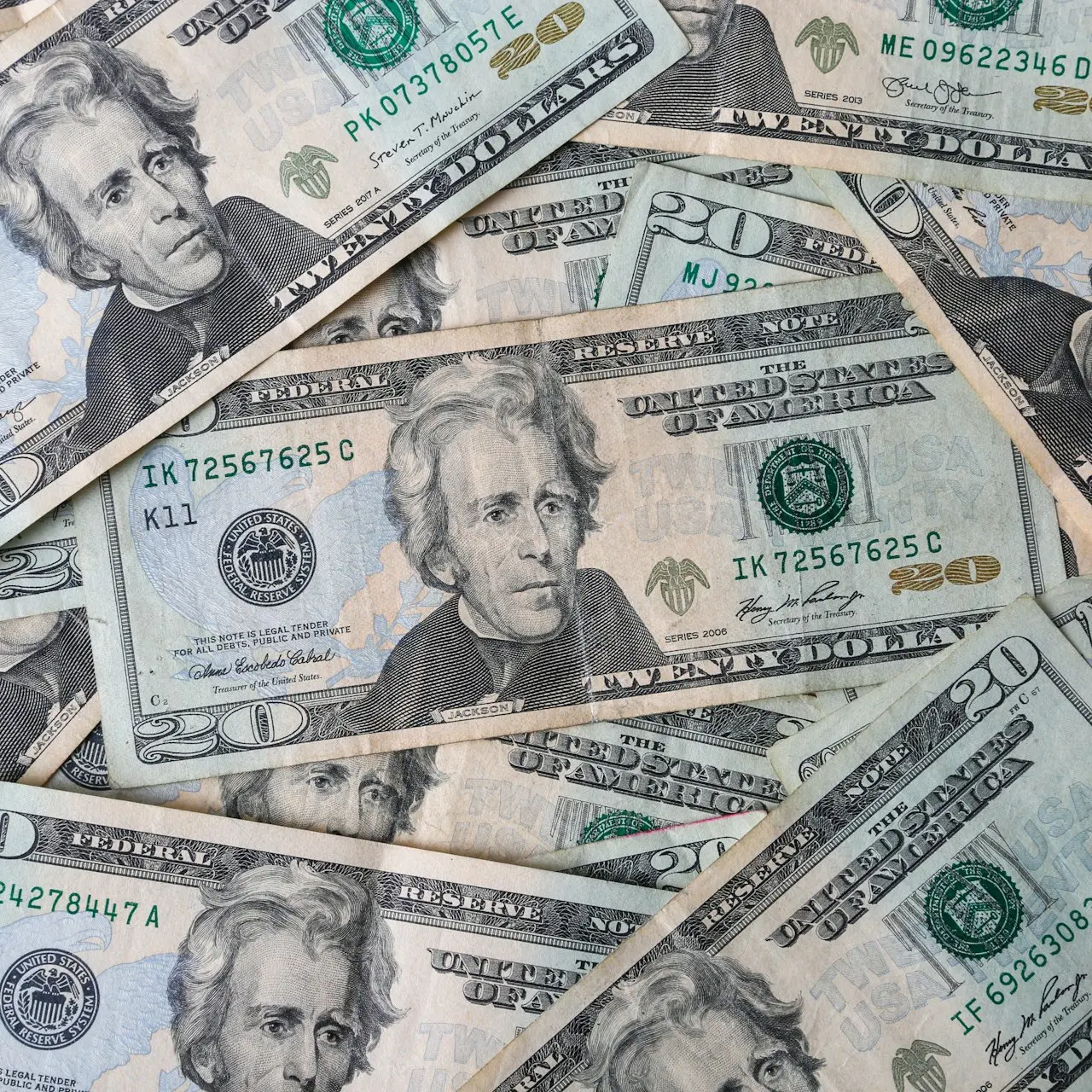 a pile of twenty dollar bills laying on top of each other