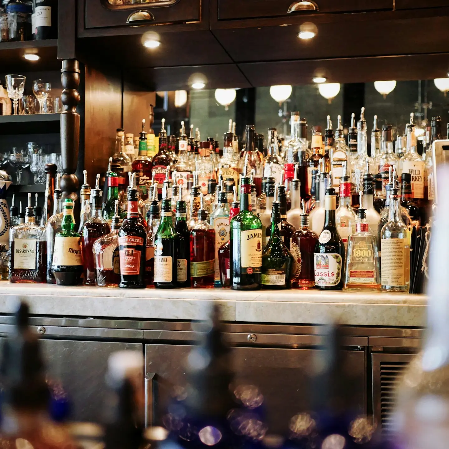 liquor bottles on white and brown wooden cabinet